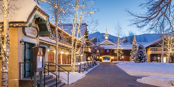 A winter nighttime photo of the Sun Valley Village outside of The Ram Restaurant with trees lit up in twinkle lights
