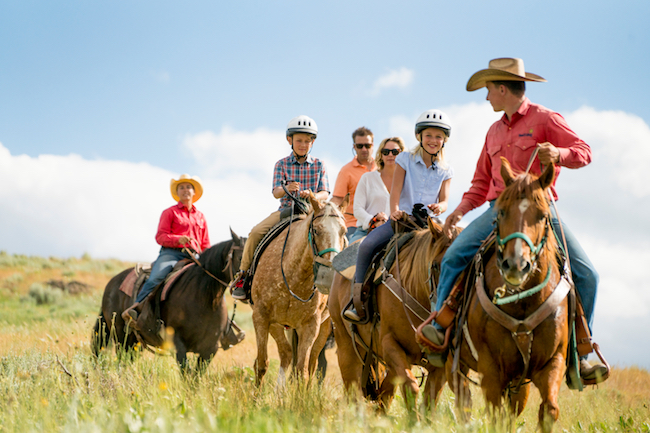 A group is led on horseback by Sun Valley Resort wrangler