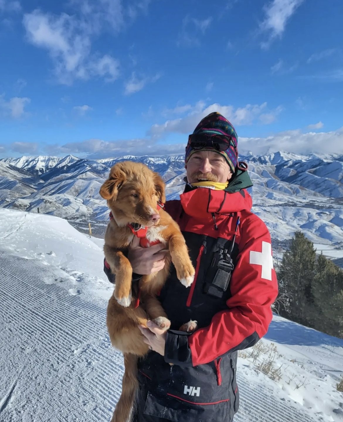 Kent, the Ski Patroller, poses holding his avalanche dog Wally.